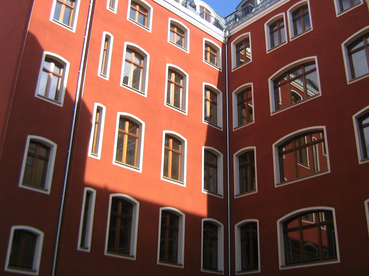 Innenhof mit roter, mineralisch gedämmter Kratzputzfassade