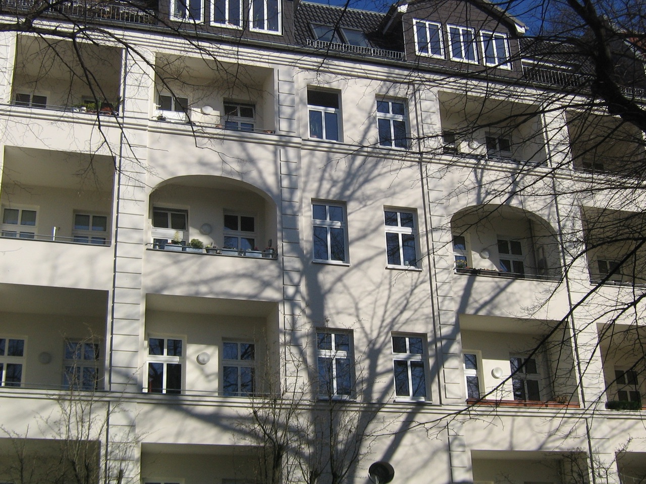 Helle Altbaufassade mit Loggien und Stuckelementen