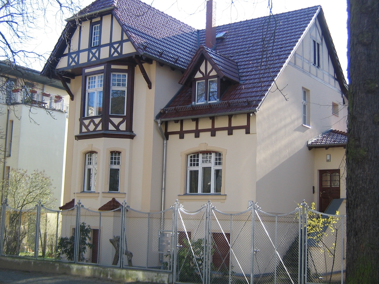 Villa mit heller Putzfassade, Fachwerkgiebeln und Erker